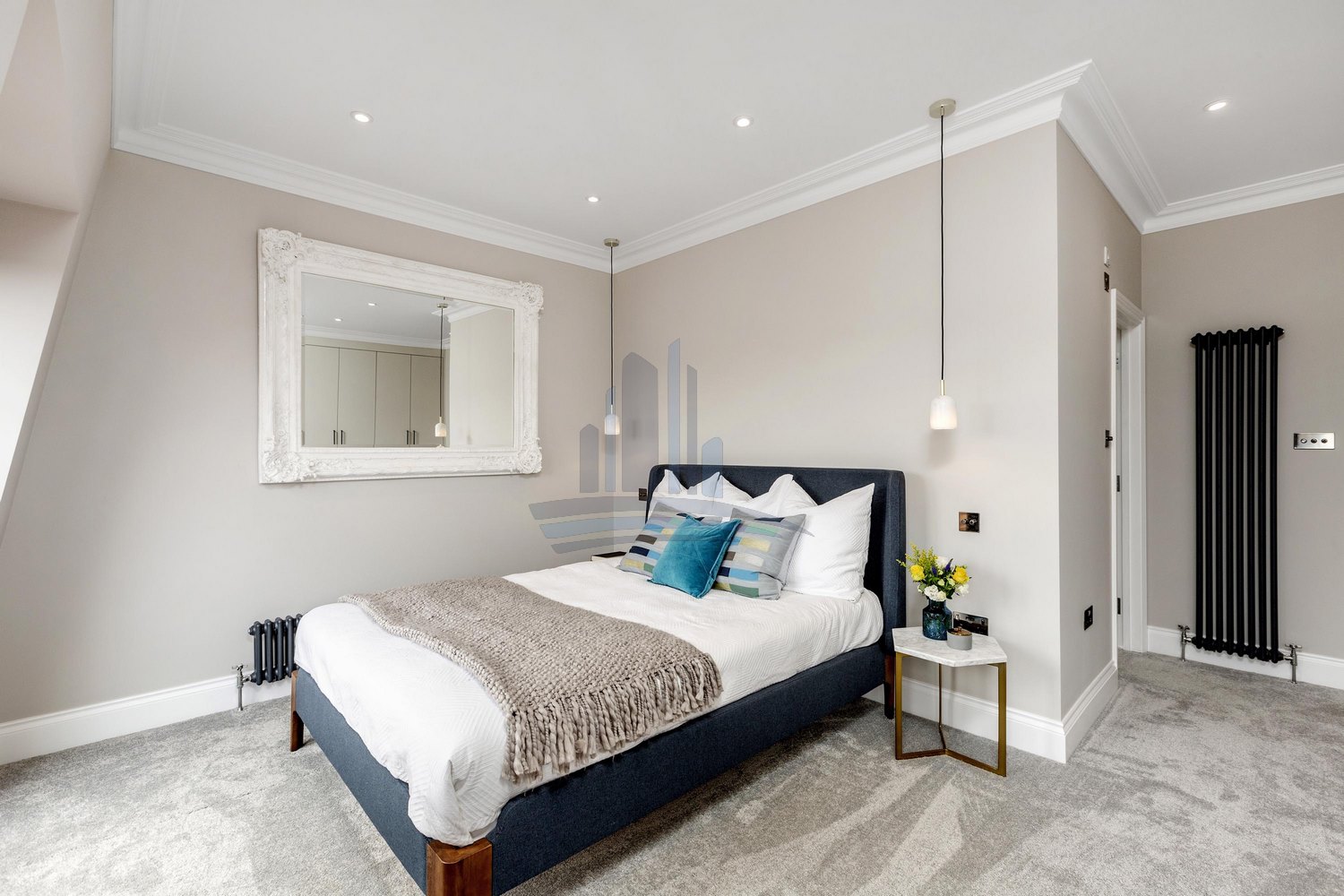 bed with pillows in bedroom with built-in wardrobe remodelled by loft conversion company london